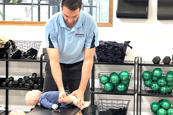 Workplace first aid practice on baby mannequins at pilates studio by WJS Training.