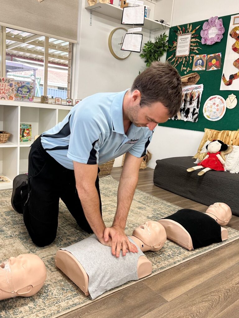 Performing compressions during corporate first aid training at Perth childcare centre